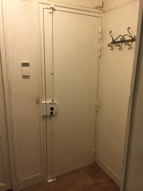 Porte blindée blanche équipée d'une serrure en applique à deux tringles