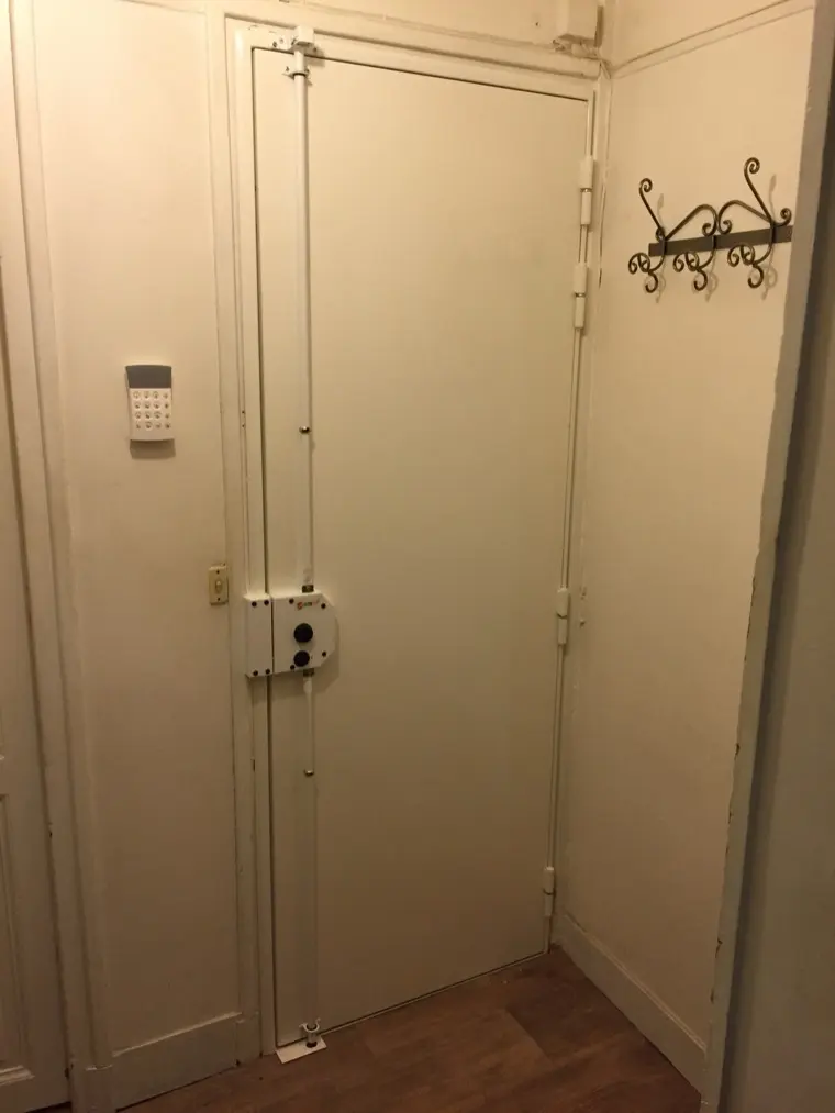 Porte blindée blanche équipée d'une serrure en applique à deux tringles