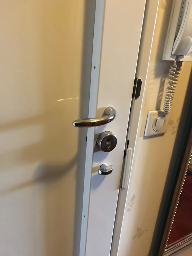 Béquille chromée et cylindre de sécurité sur une porte d'entrée