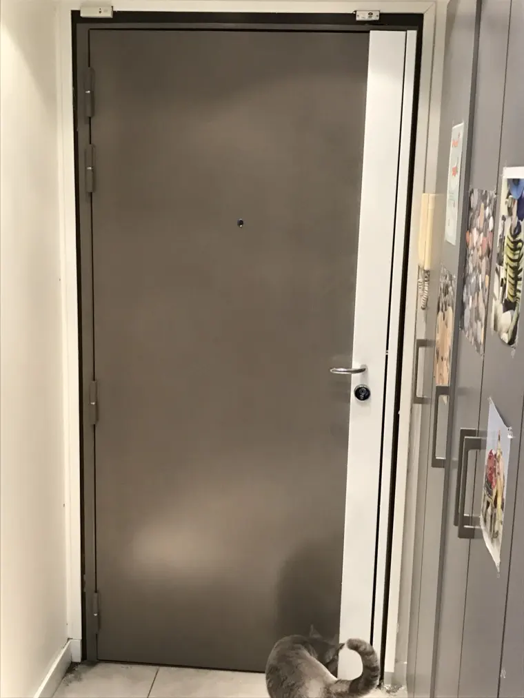 Porte blindée équipée d'un carénage blanc dans un couloir d'immeuble
