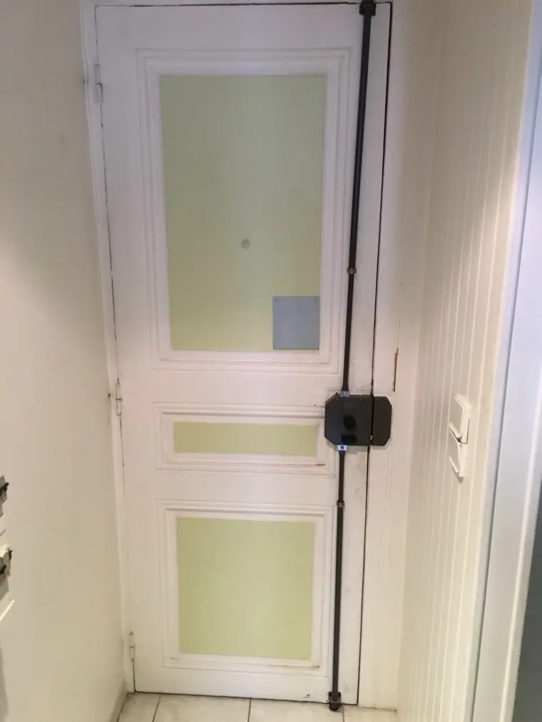 Serrure en applique montée sur une porte vitrée d'appartement