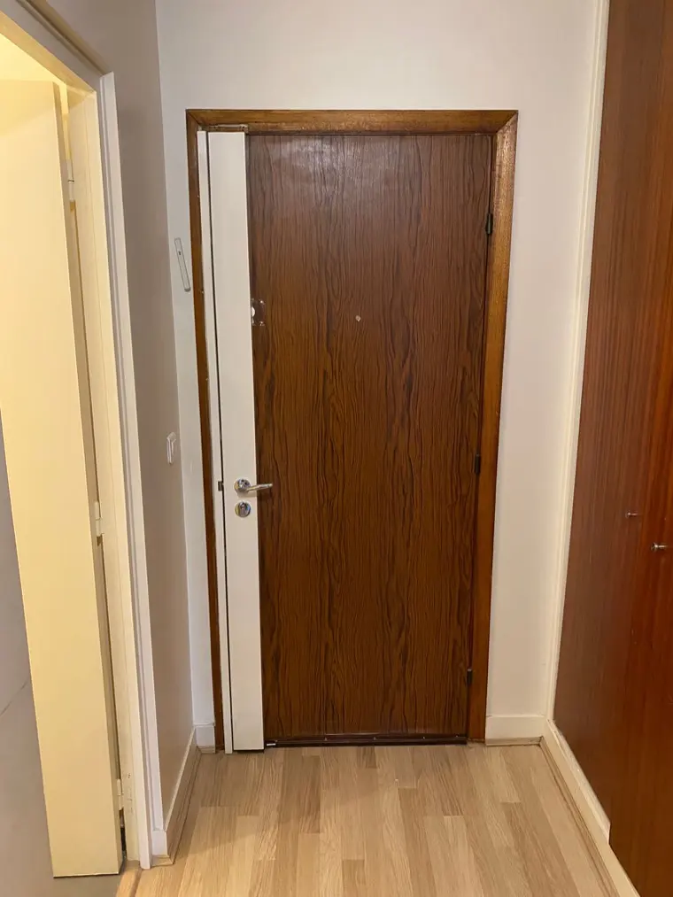 Serrure carénée blanche posée sur une porte plaquée chêne