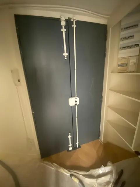 Pose d'une serrure multipoints sur une double porte, sol protégé pendant l'intervention